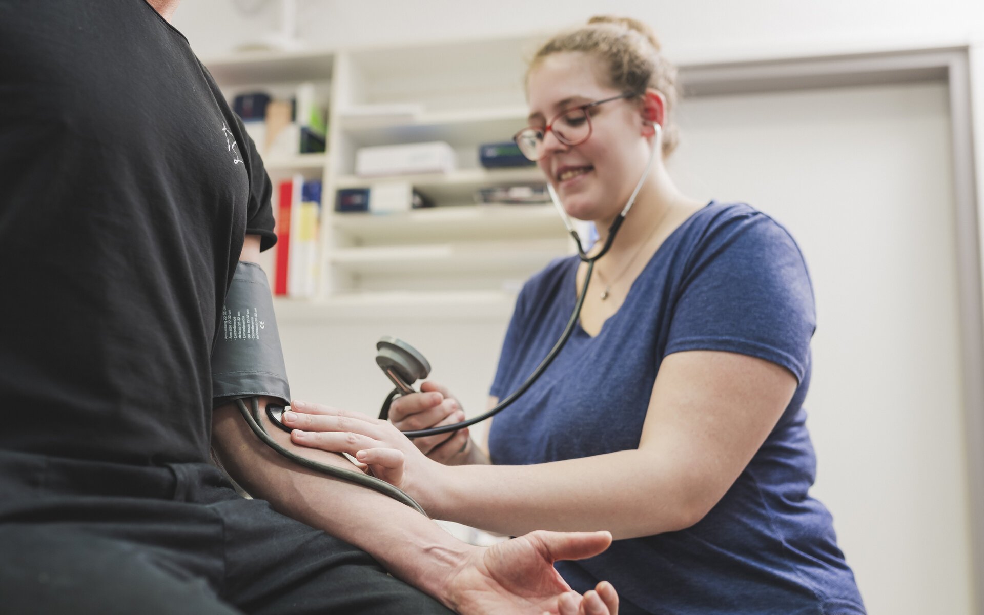 Medizinische Fachangestellte misst den Blutdruck eines Patienten